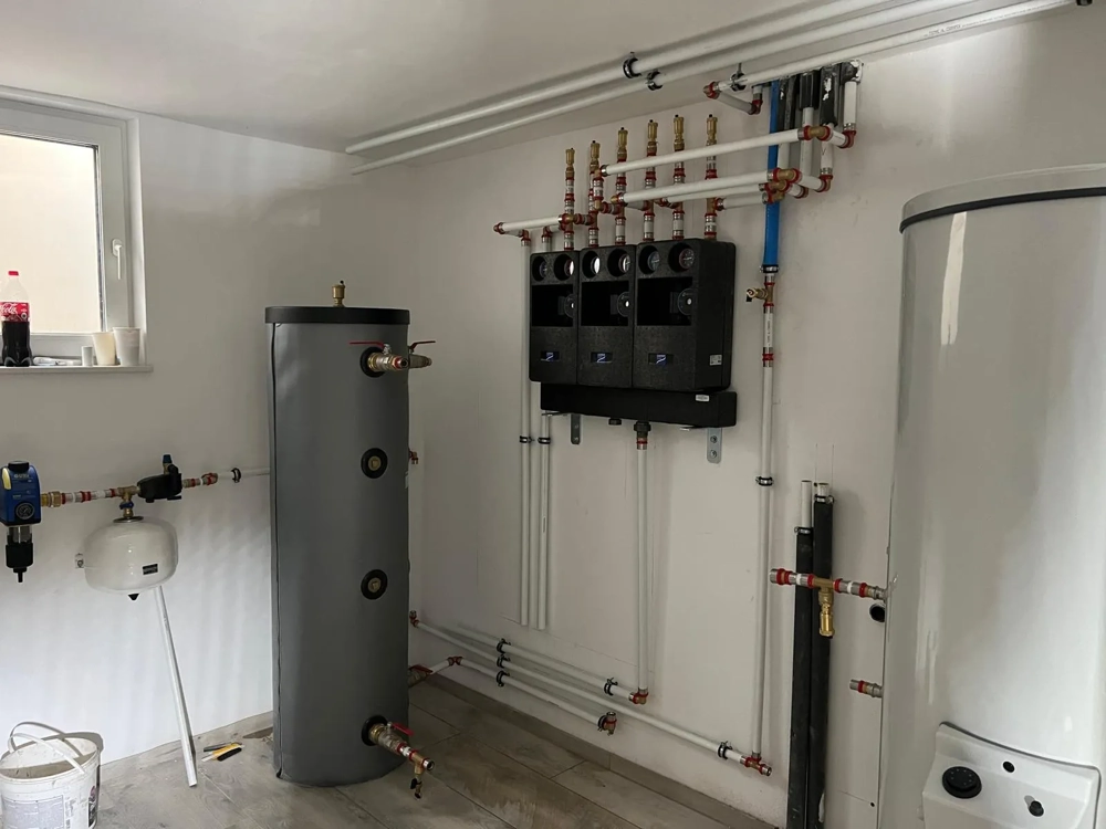 Zabudowa przewodów i modułów z pompami obiegowymi z buforem oraz zbiornikiem ciepłej wody przy instalacji pompy ciepła