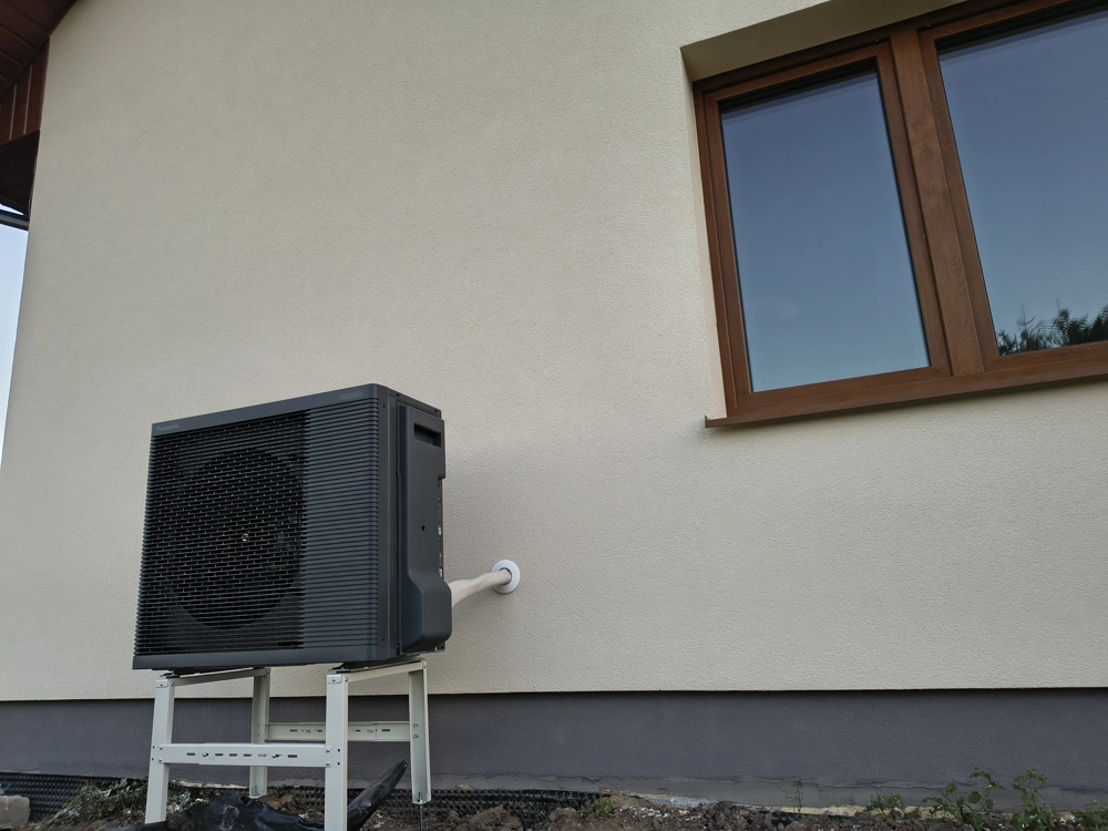 Jednostka zewnętrzna pompy ciepła powietrze-woda zamontowana na elewacji domu